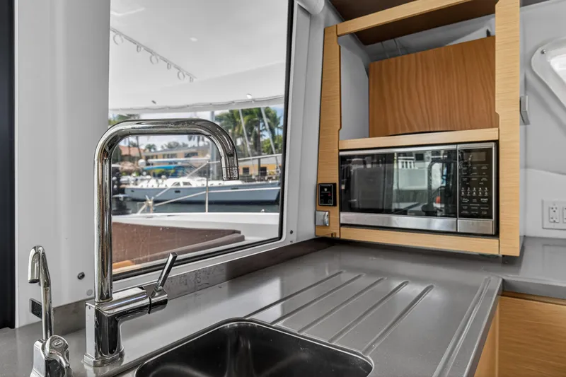 Slide: The Image of Modern kitchen area on a 2015 Fountaine Pajot Helia 44 catamaran with sink and microwave. - 66