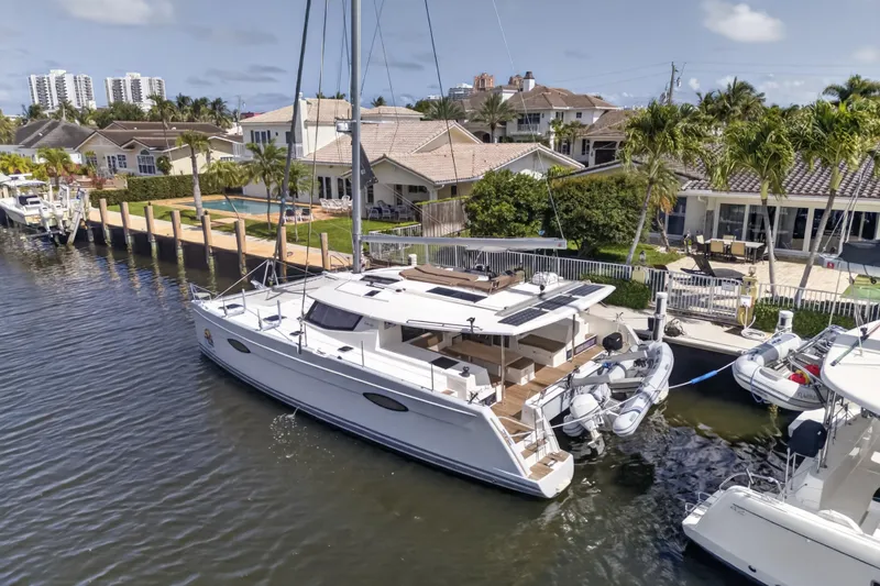 Slide: The Image of 2015 Fountaine Pajot Helia 44 catamaran docked by waterfront homes. - 8