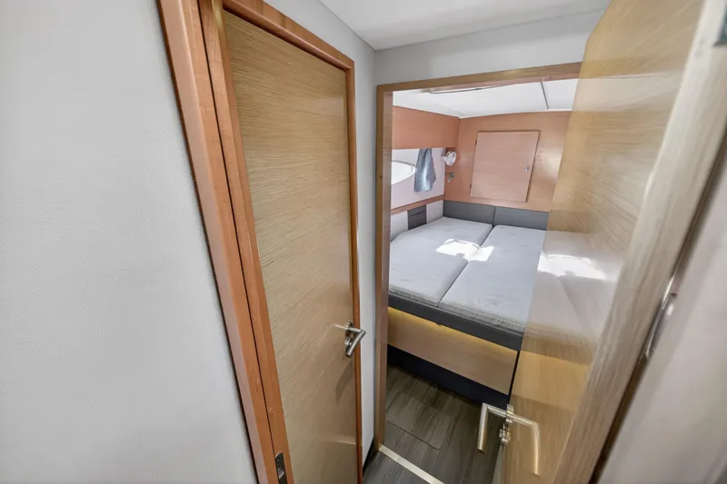 Slide: The Image of Interior cabin of 2015 Fountaine Pajot Helia 44 catamaran, featuring a cozy bed and wooden decor. - 92