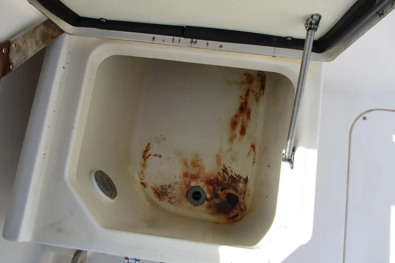 Slide: The Image of Open storage compartment with rust stains on a 1995 Grady-White Adventure 208 boat. - 18