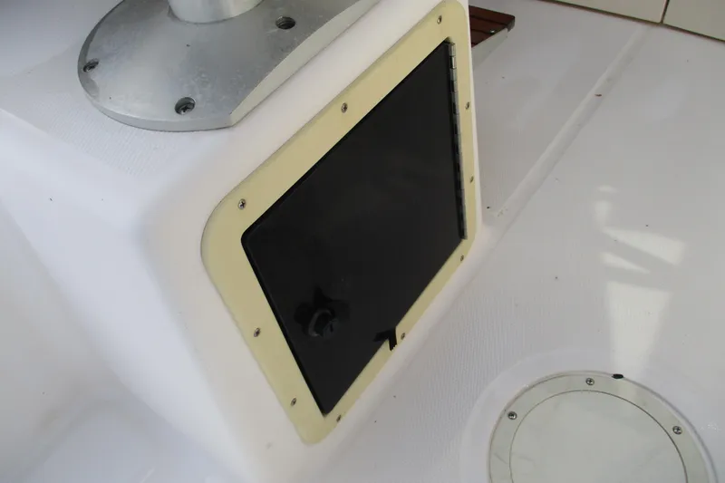 Slide: The Image of 1995 Grady-White Adventure 208 boat compartment with black hatch and white deck. - 22