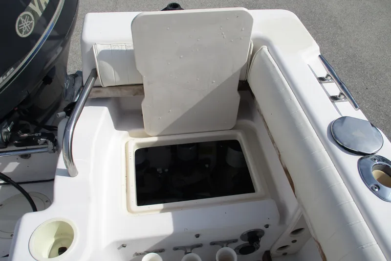 Slide: The Image of 1995 Grady-White Adventure 208 boat interior with open storage compartment and Yamaha engine. - 27