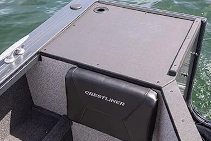 Slide: The Image of 2026 Crestliner 1850 Commander boat interior with seating and storage, on water. - 10