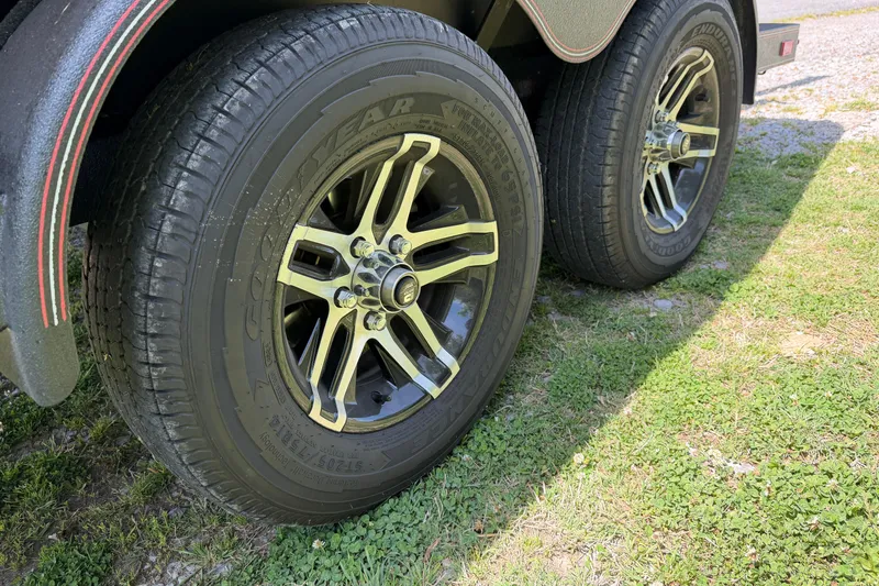 Slide: The Image of Close-up of 2025 Skeeter ZXR21 trailer wheels on grassy terrain. - 20
