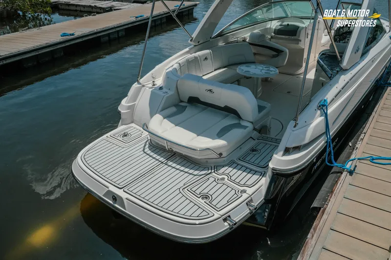 Slide: The Image of 2012 Monterey 264FS boat docked, featuring spacious seating and swim platform. - 10