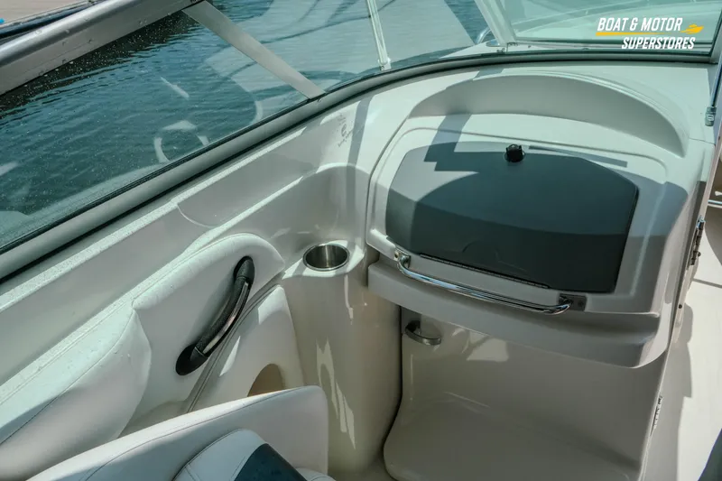 Slide: The Image of Interior view of a 2012 Monterey 264FS boat, featuring a sleek dashboard and cup holder. - 30