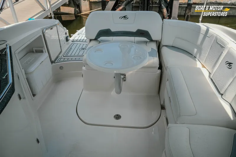 Slide: The Image of 2012 Monterey 264FS boat interior with seating and table, docked at marina. - 32