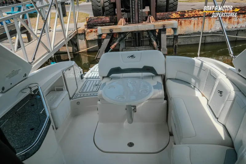 Slide: The Image of 2012 Monterey 264FS boat interior with seating and table, docked at marina. - 34