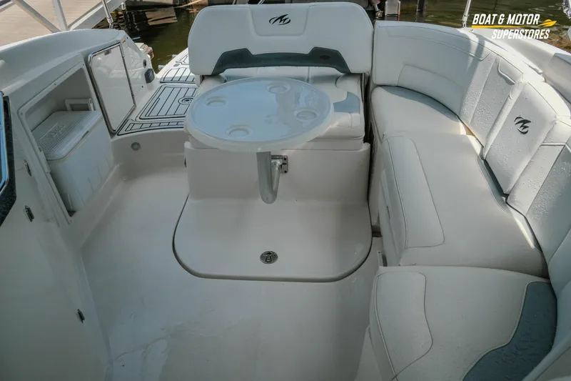Slide: The Image of 2012 Monterey 264FS boat interior with seating and table, featuring white upholstery. - 38