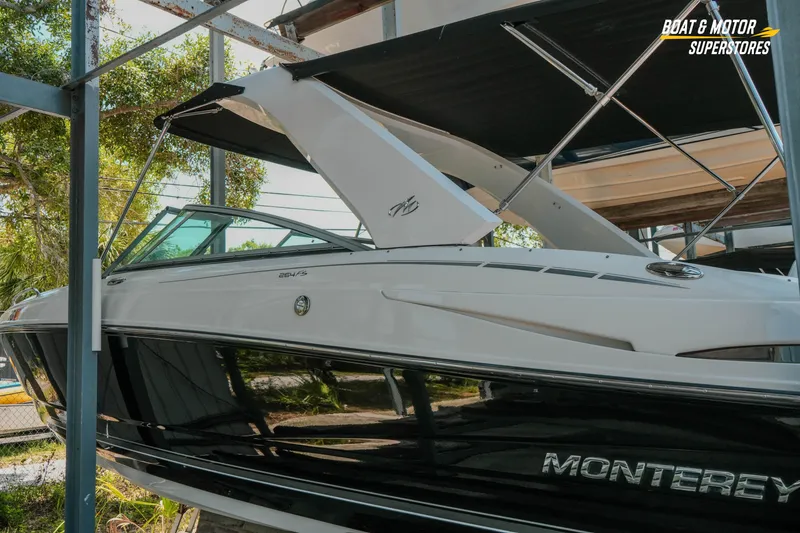Slide: The Image of 2012 Monterey 264FS boat in storage, featuring sleek design and black hull. - 4