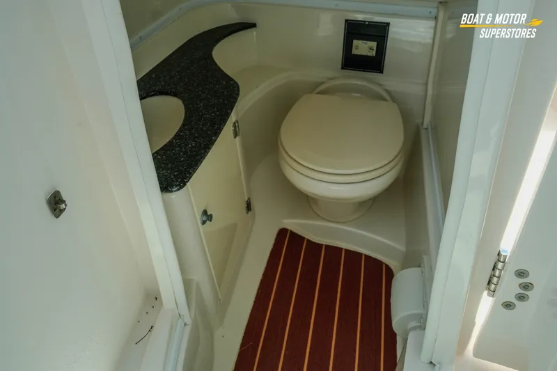 Slide: The Image of 2012 Monterey 264FS boat bathroom with toilet, sink, and striped floor mat. - 41