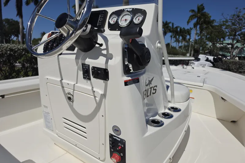 Slide: The Image of 2023 Mako 18 LTS boat console with steering wheel and gauges, set against a sunny backdrop. - 7