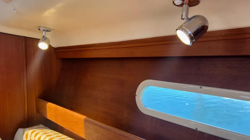 Slide: The Image of Interior of a 2001 Hunter 340 yacht with wood paneling and porthole. - 10