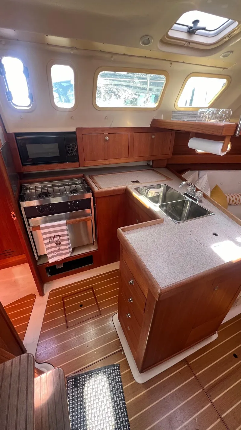 Slide: The Image of Interior of a 2001 Hunter 340 yacht with kitchen and wood paneling. - 12