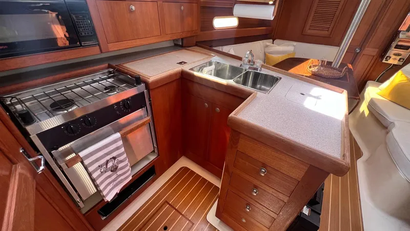Slide: The Image of Interior of 2001 Hunter 340 yacht kitchen with wooden cabinets and stainless steel sink. - 14