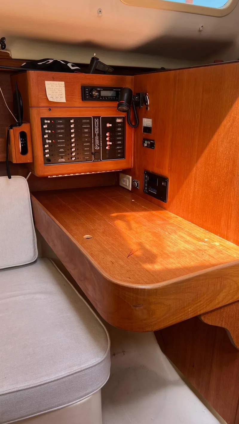 Slide: The Image of Interior of a 2001 Hunter 340 sailboat with wooden table and control panel. - 17