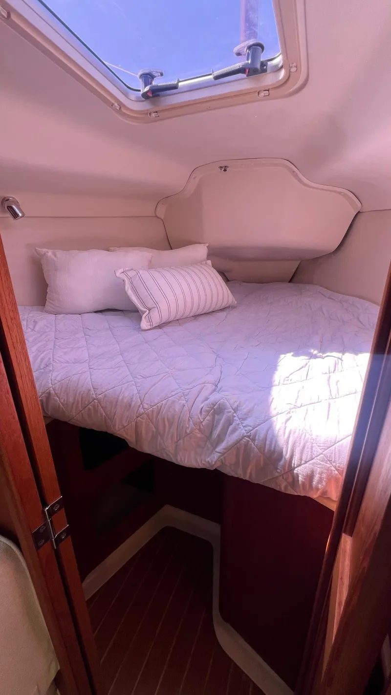 Slide: The Image of Interior of a 2001 Hunter 340 yacht featuring a cozy bed. - 25