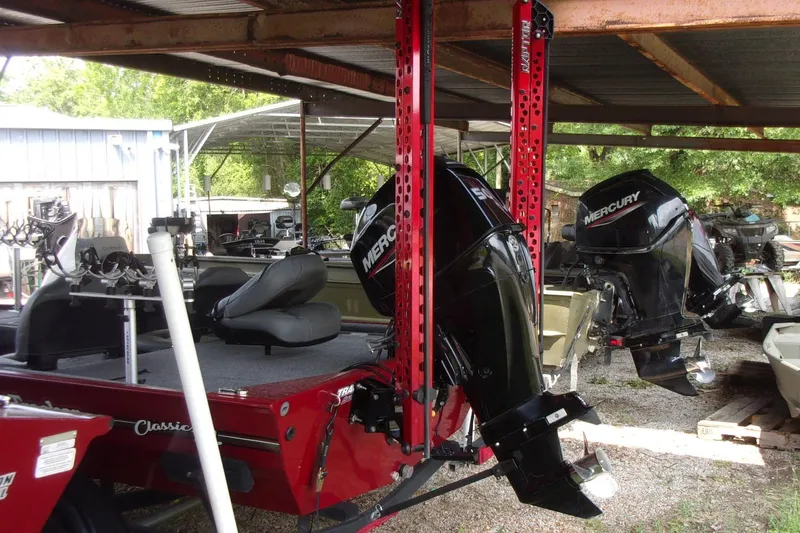 Slide: The Image of 2024 Tracker Bass Tracker Classic XL with Mercury outboard motors in a covered area. - 8