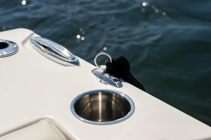 Slide: The Image of 2026 Sailfish 312 CC boat detail with stainless steel cup holder and cleat by the water. - 11