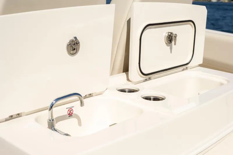Slide: The Image of 2026 Sailfish 312 CC boat sink and storage compartments on deck. - 18