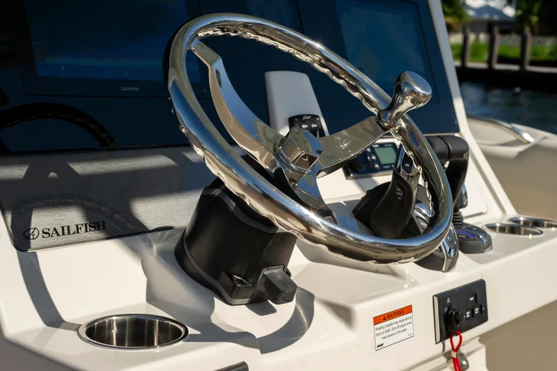 Slide: The Image of Steering wheel of 2026 Sailfish 312 CC boat with control panel and branding. - 19