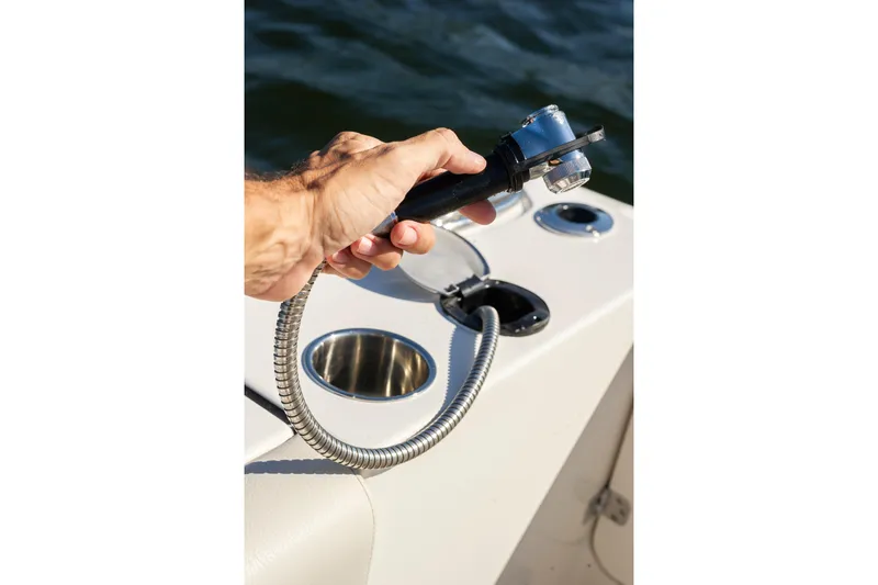 Slide: The Image of Hand holding a shower hose on a 2026 Sailfish 312 CC boat deck. - 21