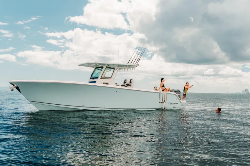 Slide: The Image of 2026 Sailfish 312 CC boat with people enjoying the ocean under a cloudy sky. - 22