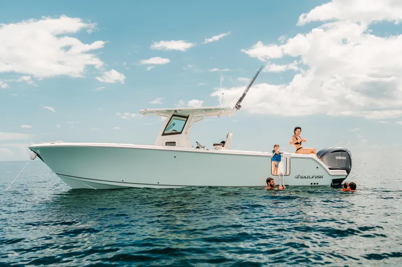 Slide: The Image of 2026 Sailfish 312 CC boat with people enjoying the ocean under a clear sky. - 23
