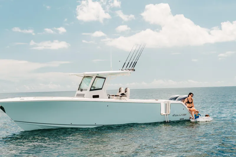 Slide: The Image of 2026 Sailfish 312 CC boat on open water with people enjoying the sea. - 24
