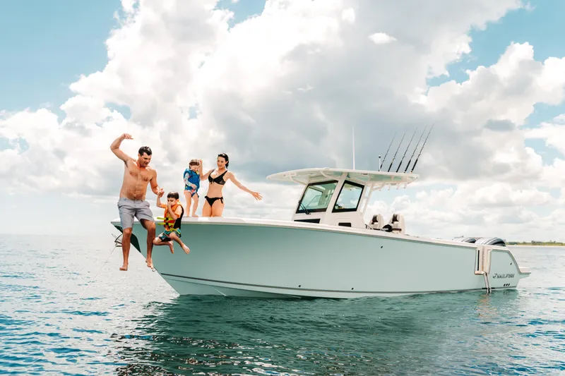 Slide: The Image of Family enjoying a day on the 2026 Sailfish 312 CC boat, jumping into the ocean. - 27