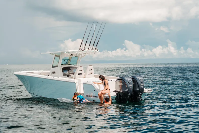 Slide: The Image of 2026 Sailfish 312 CC boat on open water, people enjoying swimming and fishing. - 28