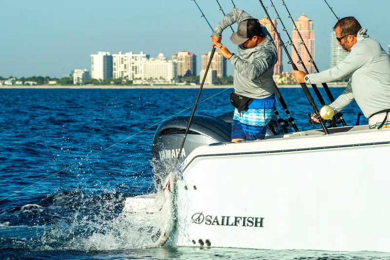 Slide: The Image of Two people fishing on a 2026 Sailfish 312 CC boat near a city skyline. - 6