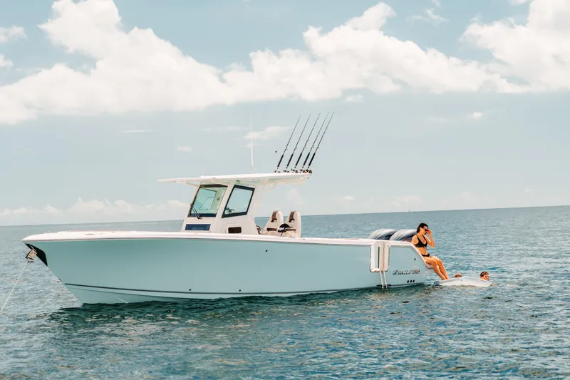 Slide: The Image of 2026 Sailfish 312 CC boat on open water with people enjoying the sea. - 7