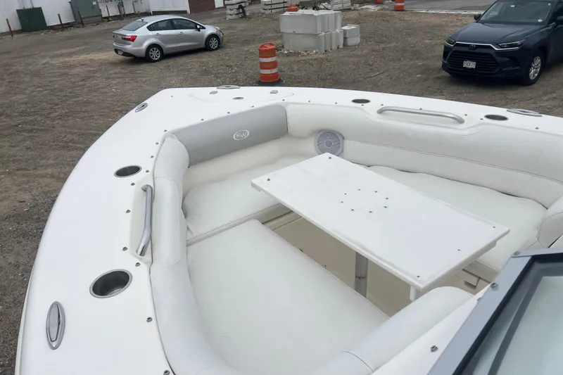 Slide: The Image of 2022 Key West 239 DFS boat with white seating and table, parked on gravel. - 19