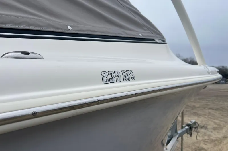 Slide: The Image of 2022 Key West 239 DFS boat side view with cover, showcasing sleek design. - 32