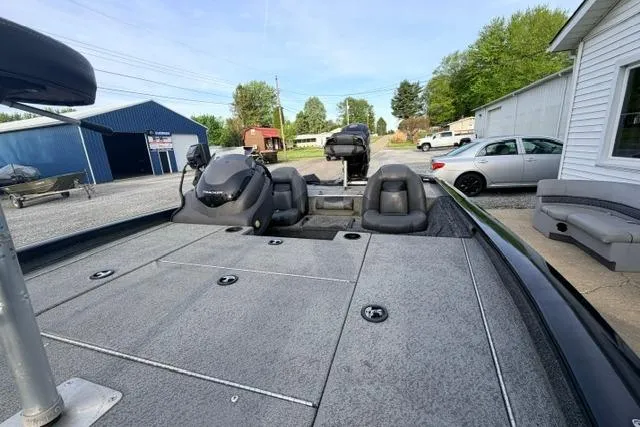 Slide: The Image of 2019 Bass Tracker Pro 19 boat with spacious deck and seating, parked outdoors. - 10