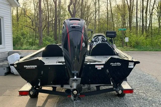 Slide: The Image of 2019 Bass Tracker Pro 19 boat parked on a driveway near a wooded area. - 4