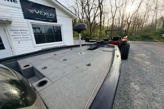 Slide: The Image of 2019 Bass Tracker Pro 19 boat parked outside Vexus showroom with trees in the background. - 7