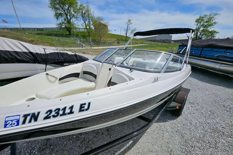 Slide: The Image of 2015 Stingray 180 RX boat on trailer, parked outdoors under a clear sky. - 3