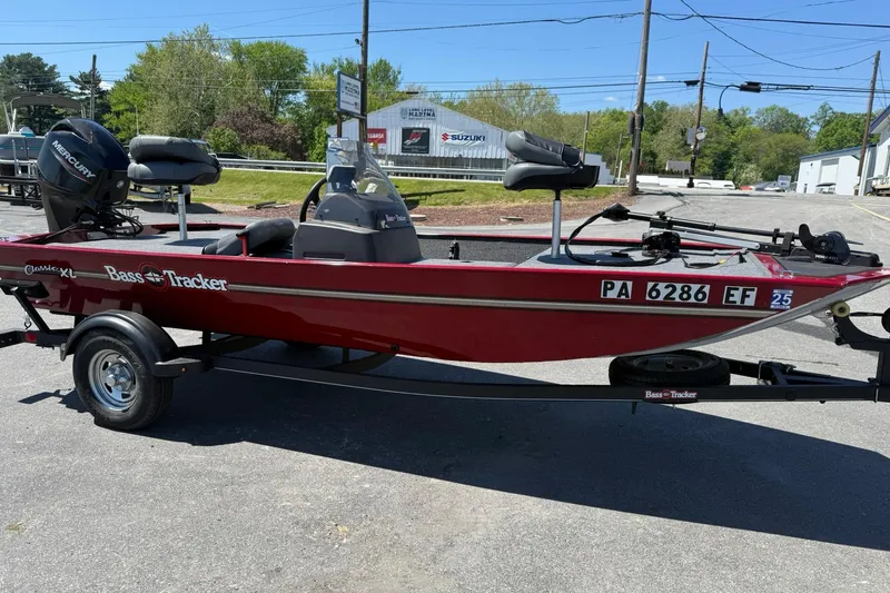 Slide: The Image of 2020 Tracker Bass Tracker Classic XL boat on trailer, red exterior, parked outdoors. - 4