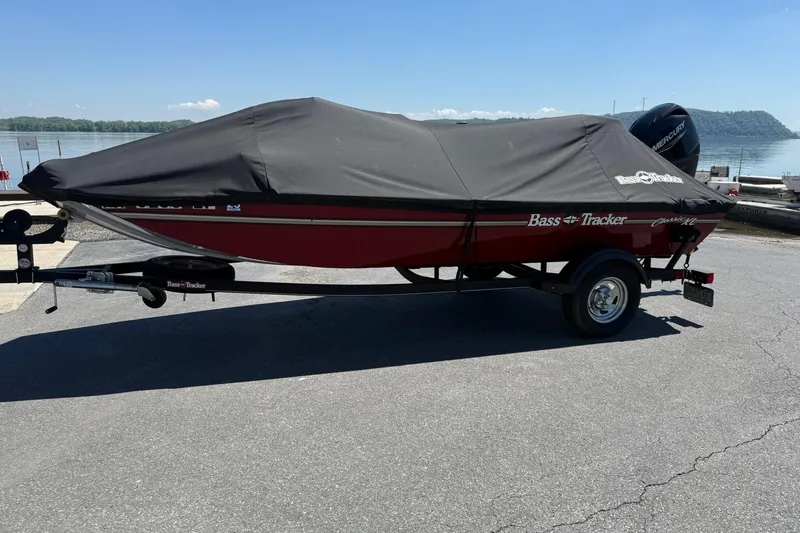 Slide: The Image of 2020 Tracker Bass Tracker Classic XL boat covered, parked near a lake. - 5
