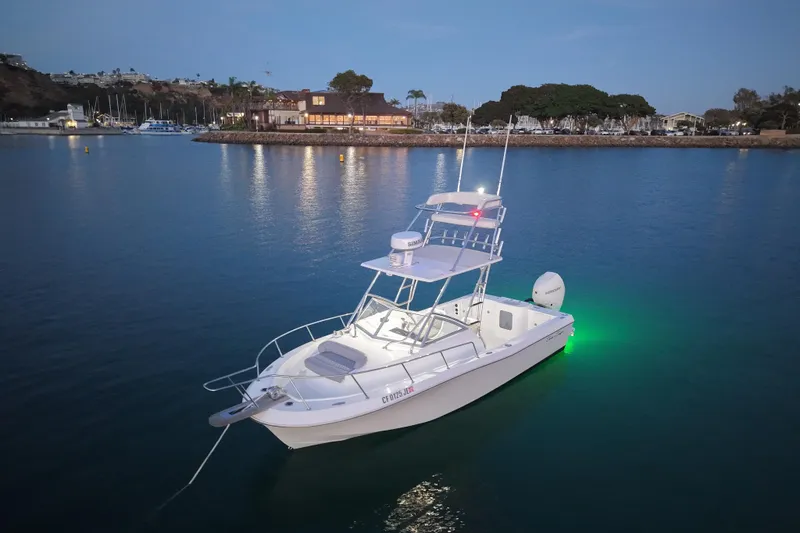 Slide: The Image of 1985 Chris-Craft 21 Scorpion Cuddy boat anchored in calm waters at dusk. - 12