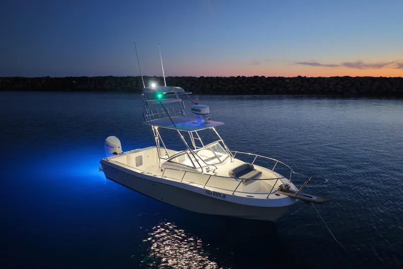 Slide: The Image of 1985 Chris-Craft 21 Scorpion Cuddy boat illuminated at sunset on calm water. - 16