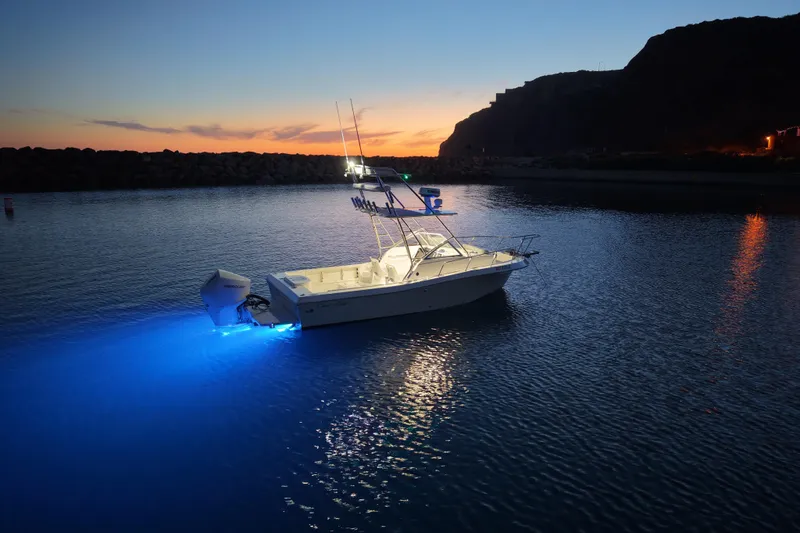 Slide: The Image of 1985 Chris-Craft 21 Scorpion Cuddy boat illuminated on water at sunset. - 18