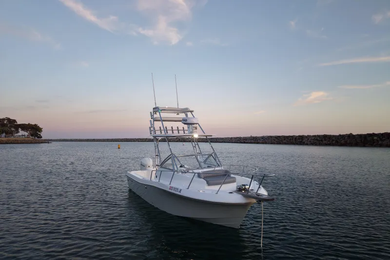 Slide: The Image of 1985 Chris-Craft 21 Scorpion Cuddy boat anchored in calm waters at sunset. - 2