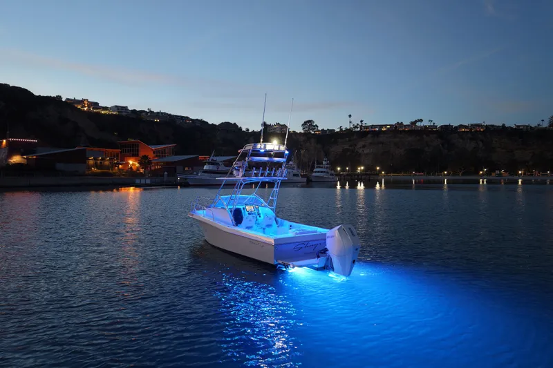 Slide: The Image of 1985 Chris-Craft 21 Scorpion Cuddy boat illuminated at night on calm water. - 23