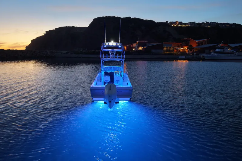 Slide: The Image of 1985 Chris-Craft 21 Scorpion Cuddy with blue underwater lights at dusk in a marina. - 26