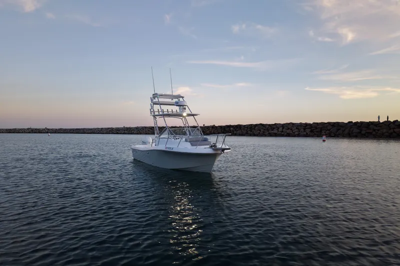 Slide: The Image of 1985 Chris-Craft 21 Scorpion Cuddy boat on calm water at sunset. - 3