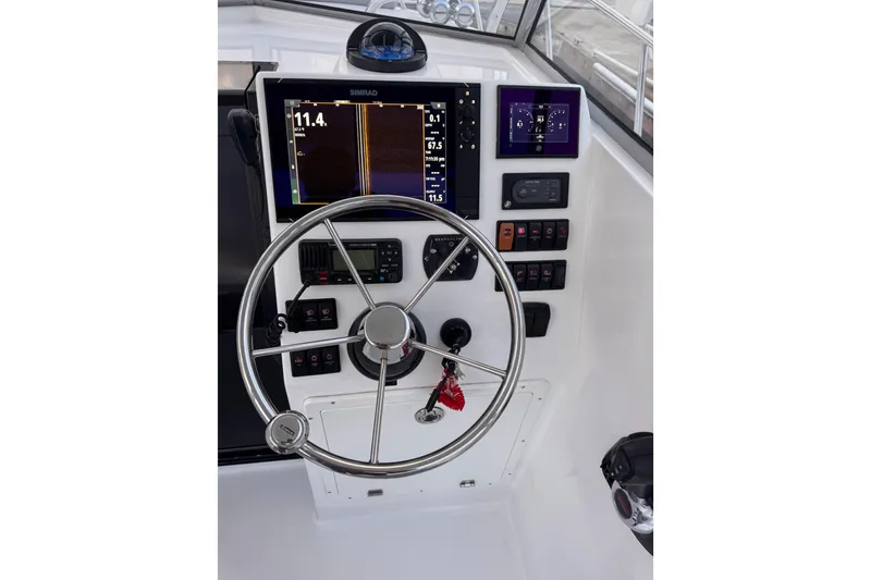 Slide: The Image of 1985 Chris-Craft 21 Scorpion Cuddy helm with modern navigation equipment and steering wheel. - 30