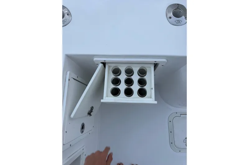 Slide: The Image of 1985 Chris-Craft 21 Scorpion Cuddy boat storage compartment with open hatch and rod holders. - 34
